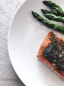 baked salmon on dinner plate with asparagus