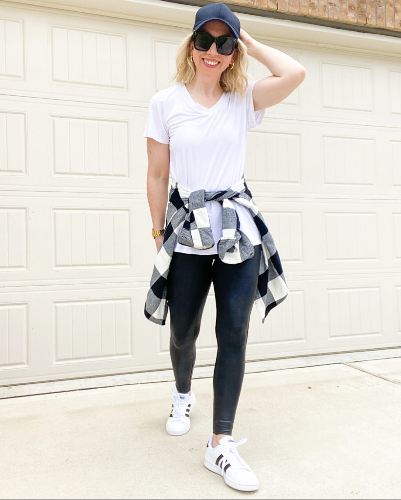 woman-standing-wearing-white-tee-with-spanx-faux-leather-leggings-sneakers-and-flannel-shirt-tied-around-the-waist