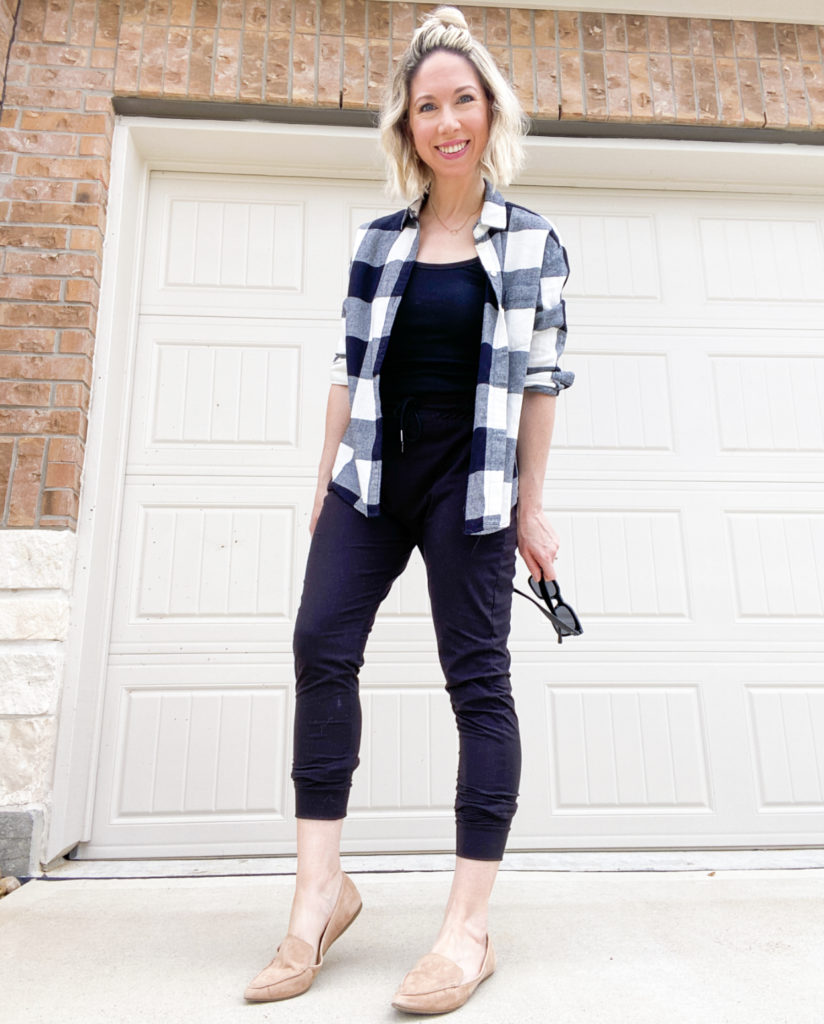 woman-standing-wearing-flannel-shirt-untucked-and-open-over-top-a-tank-top-with-joggers-and-tan-suede-loafers